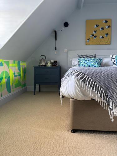 a bedroom with a bed and a dresser at Hues - Castle Cary in Castle Cary