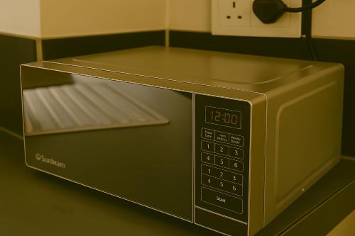 een magnetron op een aanrecht bij Charming apartment With Private Balcony in Johannesburg