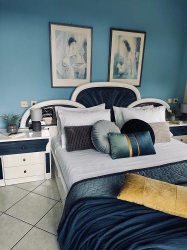 a bedroom with two beds and a blue wall at Theros Seaside House - Volos in Marathos