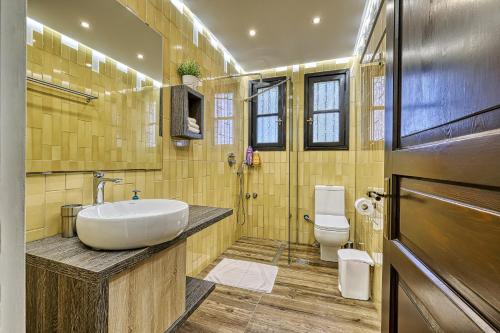 a bathroom with a sink and a toilet at Orange Grove Villa in Nafplio