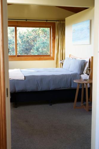 a bedroom with a large bed and a window at Above the Bay in Hahei