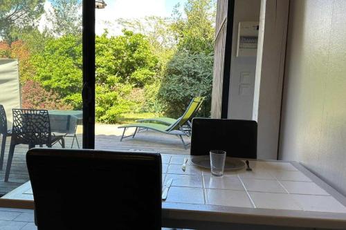 - une table et des chaises dans une chambre avec terrasse dans l'établissement Beautiful house with garden - near park, à Gujan-Mestras