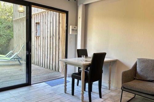 une salle à manger avec une table et des chaises et un balcon dans l'établissement Beautiful house with garden - near park, à Gujan-Mestras
