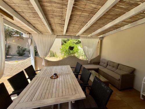 a patio with a table and chairs and a couch at Casa Teresa in Porto Pino