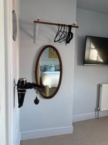a mirror on a wall in a room with a bed at Hues - Castle Cary in Castle Cary