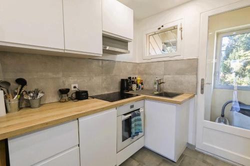 une cuisine avec des armoires blanches et un évier dans l'établissement Apartment for 2 - sea view, à Toulon