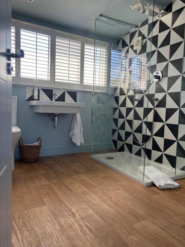 a bathroom with a glass shower and a sink at Hues - Castle Cary in Castle Cary