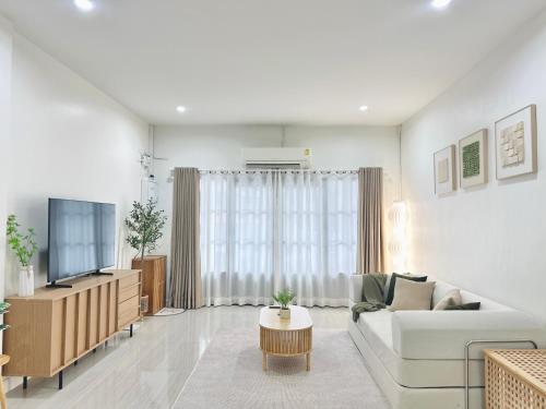 a living room with a couch and a tv at Midori Haus-7mins to LeeGarden in Hat Yai