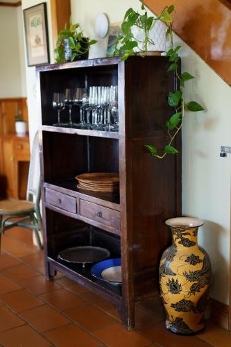 a wooden shelf with a vase in a room at Above the Bay in Hahei