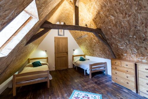 a bedroom with two beds in a attic at Maison De Vacances Chêne in Auriac-du-Périgord