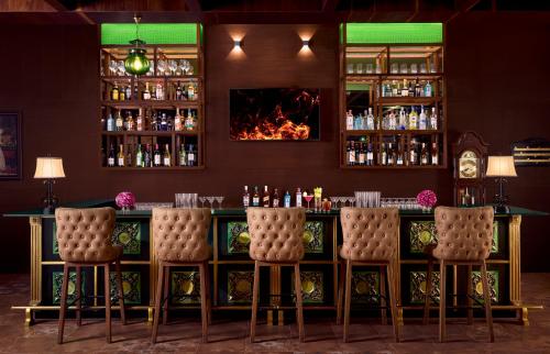 a bar with chairs and a fireplace in a room at Gateway Coorg in Madikeri