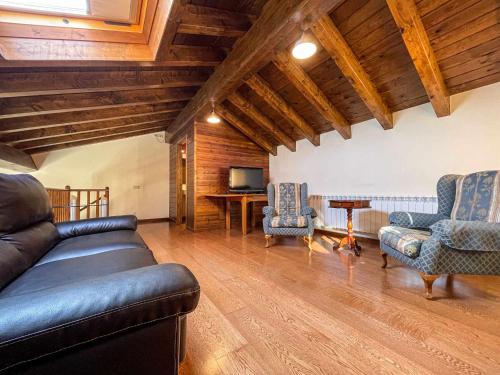 a living room with a leather couch and two chairs at Cal Vilaldach in Llivia