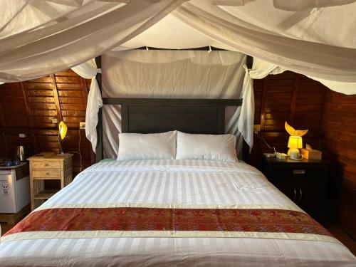 a bedroom with a large bed with a canopy at Villa Rumah Kayu Lovina in Lovina