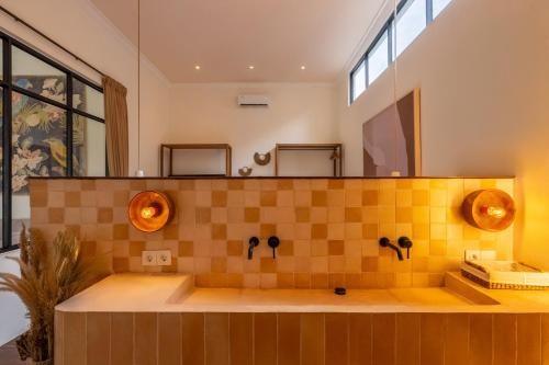 een badkamer met een bad met gele tegels bij Sofia Villa by betterplace in Canggu