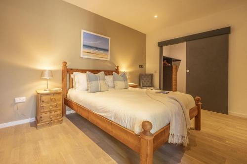a bedroom with a large bed with a wooden bed frame at The Neuk in Kincraig