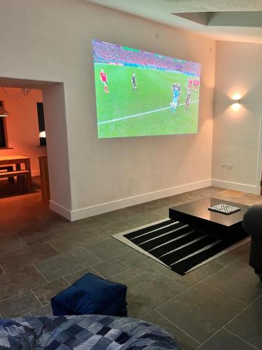 a living room with a tv hanging on the wall at The Piggery near Bruton in Evercreech