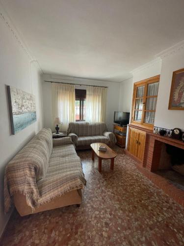 a living room with a couch and a tv at chalet Mazagón in Moguer