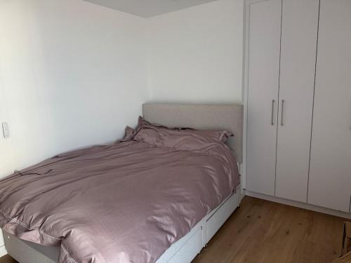 a bed in a room with a white cabinet at Apartment in Kent Beachfront NEW in Ramsgate
