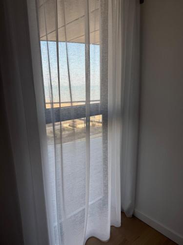 a window with white curtains in a room at Apartment in Kent Beachfront NEW in Ramsgate