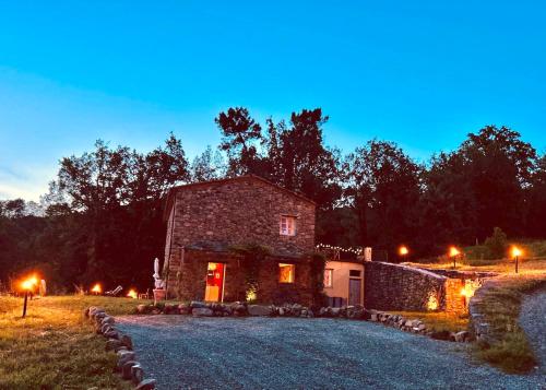 a stone house sitting on a field at night at Casa Valle Verde in Brugnato