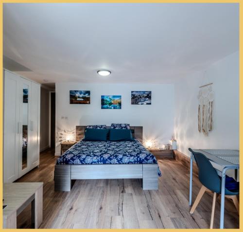 une chambre avec un lit, une table et des chaises dans l'établissement Chez Bert I Studio I Perrignier, à Perrignier