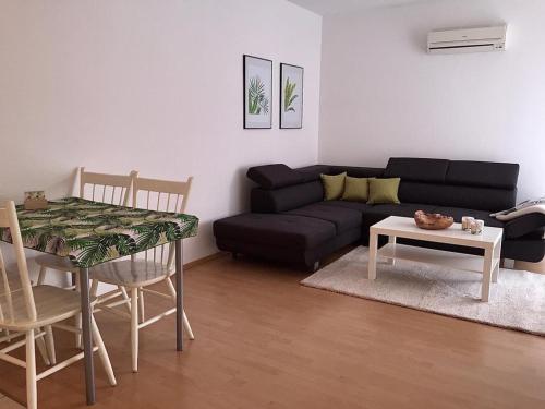 a living room with a black couch and a table at App Marina NOVI in Novi Vinodolski