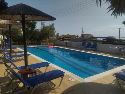 a swimming pool with chairs and an umbrella at Marieva Sea View Apartments in Kanali
