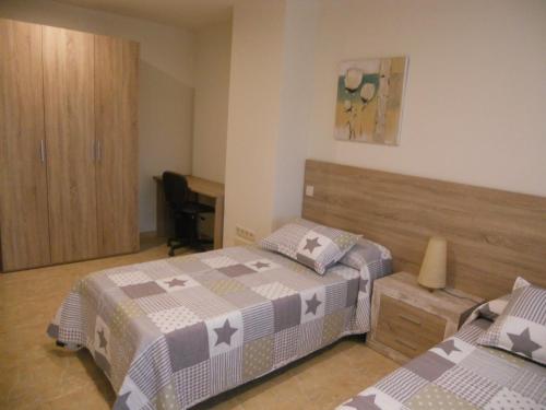 1 Schlafzimmer mit 2 Betten und einem Schreibtisch in der Unterkunft Apartament Sant Quirze de Besora in Sant Quirze de Besora