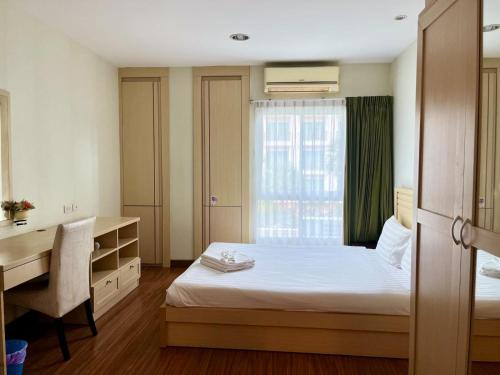 a bedroom with a bed and a desk and a window at Luxury Villa Patong in Patong Beach