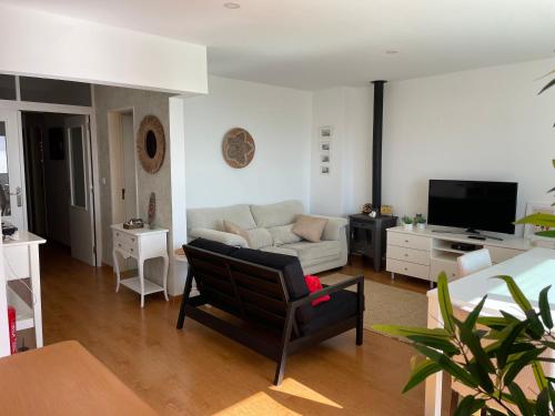 ein Wohnzimmer mit einer Couch und einem Sessel in der Unterkunft Santa Cruz Sunset in A dos Cunhados