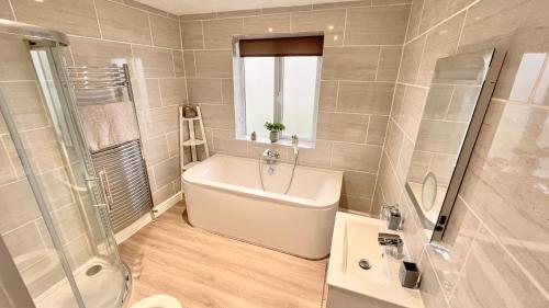 a bathroom with a tub and a shower and a sink at Carnmhor, Isle of Skye - Stunning 242 year old cottage on its own sea shore! in Breakish
