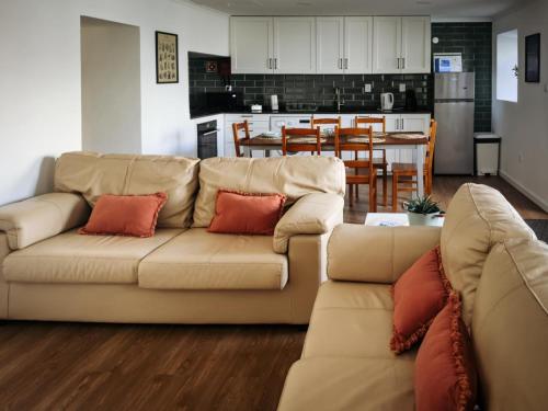 a living room with a couch and a kitchen at Casa da Leocádia in Rosais