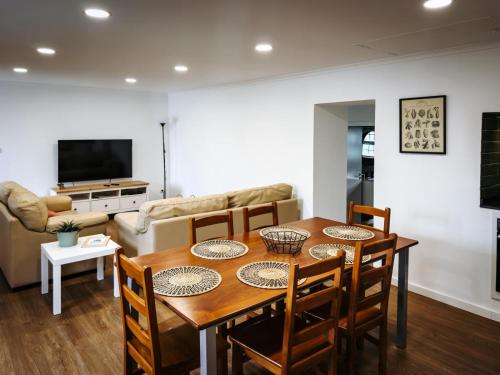 a dining room with a table and chairs and a couch at Casa da Leocádia in Rosais