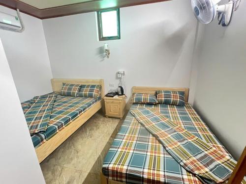 a room with two beds in a room at Homestay duy mạnh gần suối nước khoáng nóng trạm tấu in Cham Ta Lao