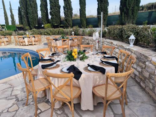 a table set up for a wedding in front of a pool at Ambelli Villa 4 Bedroom Luxury Villa in Skarinou