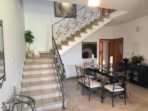 a dining room with a staircase and a table and chairs at Ambelli Villa 4 Bedroom Luxury Villa in Skarinou