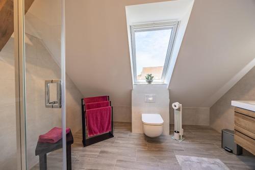 a bathroom with a toilet and a window at Haus Grande-Familienidyll am See in Neubrandenburg