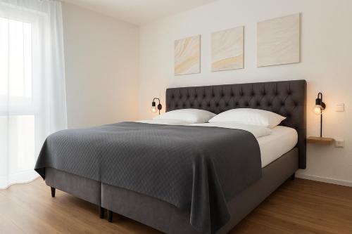 a bedroom with a large bed with white pillows at Schlüssel Apartments in Lahr