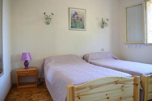 une chambre avec deux lits et une table avec une lampe dans l'établissement Maison 4 pièces 7 couchages ARGELES SUR MER AR000-067, à Argelès-sur-Mer