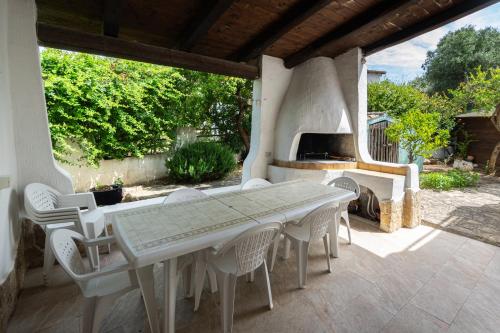 a table and chairs on a patio with a fireplace at Villa fantastica Villasimius in Capitana