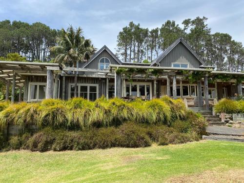 a house with a palm tree in front of it at Above the Bay in Hahei