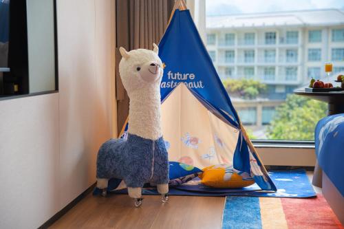 a stuffed llama standing next to a toy tent at Zhangjiajie Yujie Hotel in Zhangjiajie