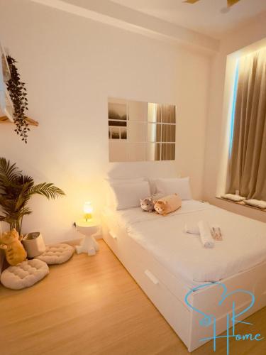 a bedroom with a white bed with two cats on it at Sunway GRID by SR Home in Kampong Pendas
