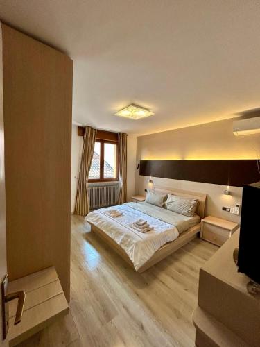a bedroom with a large bed and a television at B&B al Vittoriale da Maja in Gardone Riviera