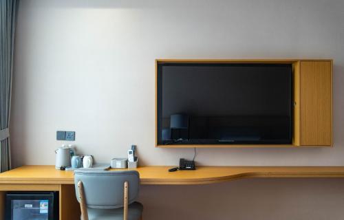 a large flat screen tv on a wall with a chair at U&ME HOTEL Segamat Sdn Bhd in Segamat