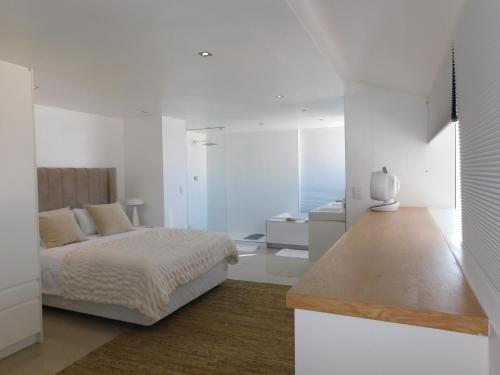 a bedroom with a bed in a white room at Penthouse Strand in Strand
