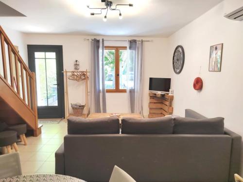 a living room with a couch and a television at Gîte des deux platanes in Orgon