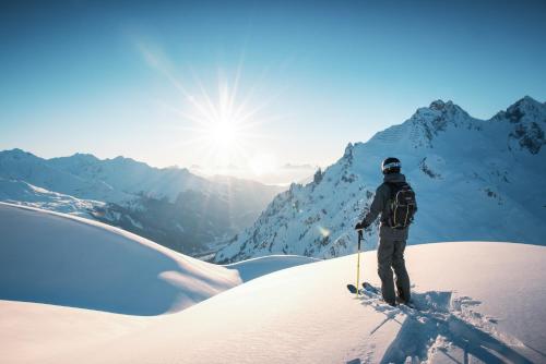 a person on skis standing on a snow covered mountain at Arlberg Motel Ski-In & Ski-Out access to Austrias largest ski area in Stuben am Arlberg
