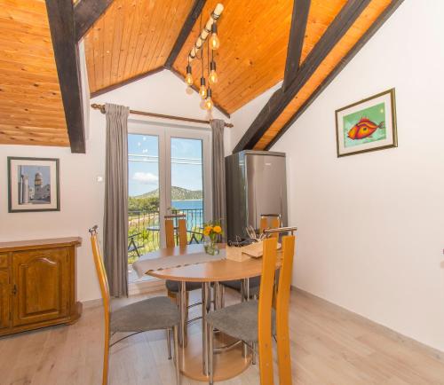 a kitchen and dining room with a table and chairs at Apartments Njoko in Prvić Šepurine