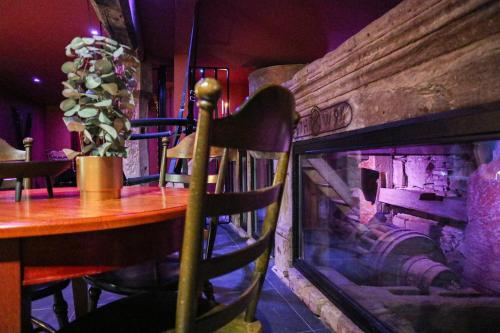 une salle à manger avec une table et une cheminée dans l'établissement LE MOULIN DES PLAISIRS atypical SM experience, à Wentzwiller